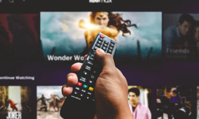 Uomo con telecomando TV (© Depositphotos)